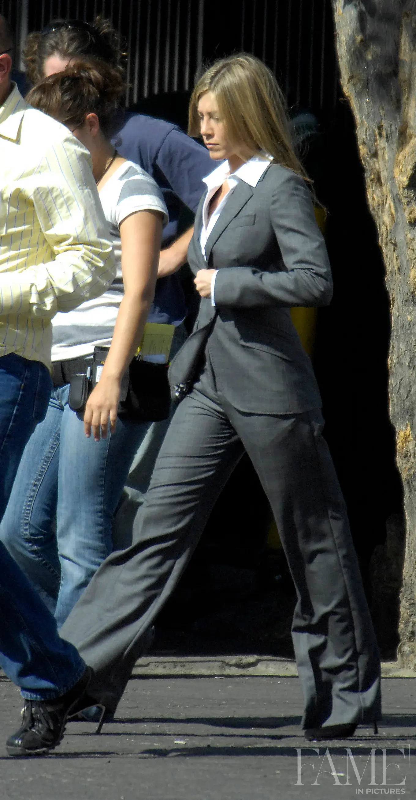 Jennifer Aniston in a grey suit on a Los Angeles film set in 2007