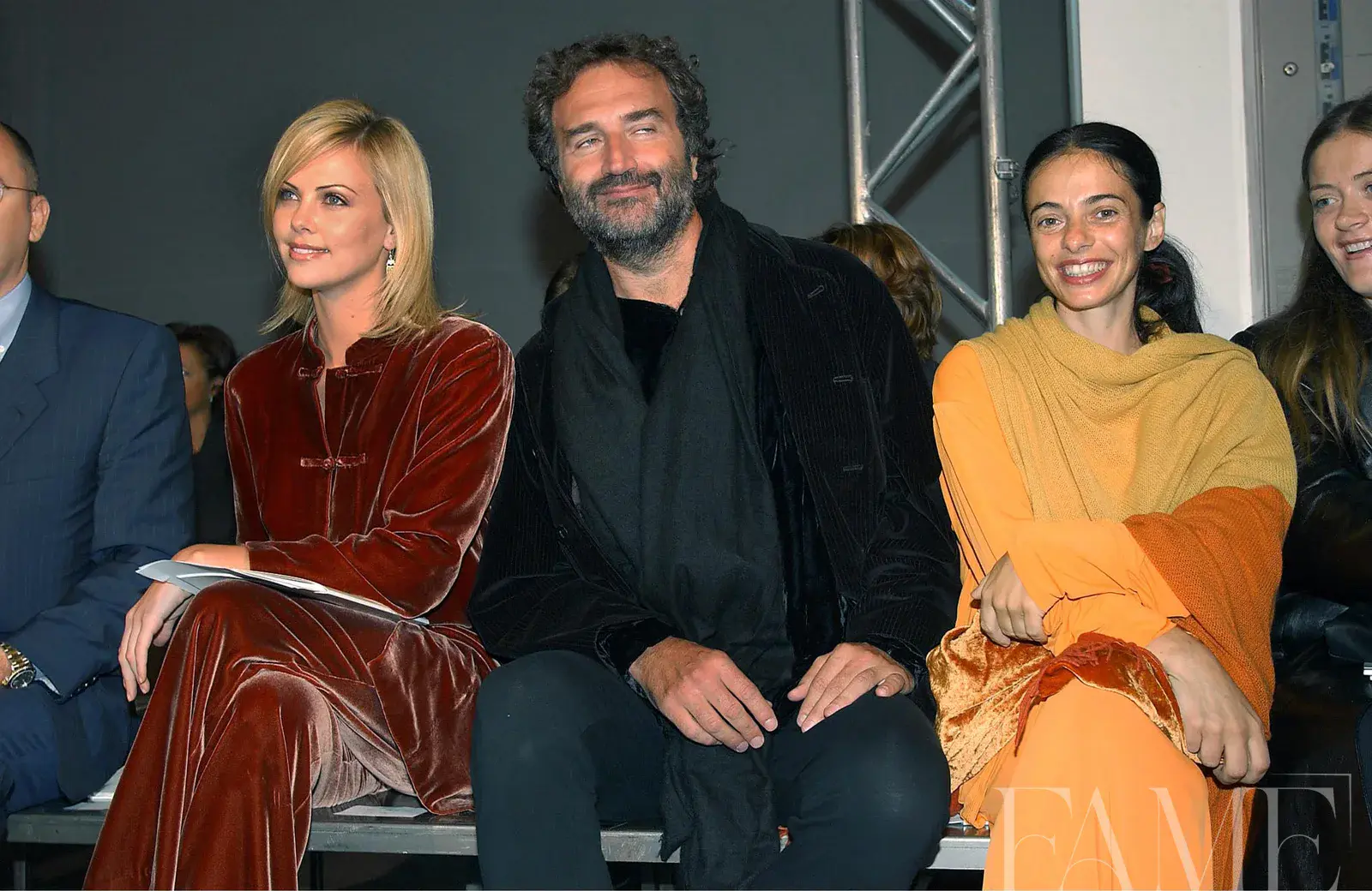 Charlize Theron seated with Fabrizio Ferri and another guest at the Blunauta show in 2001