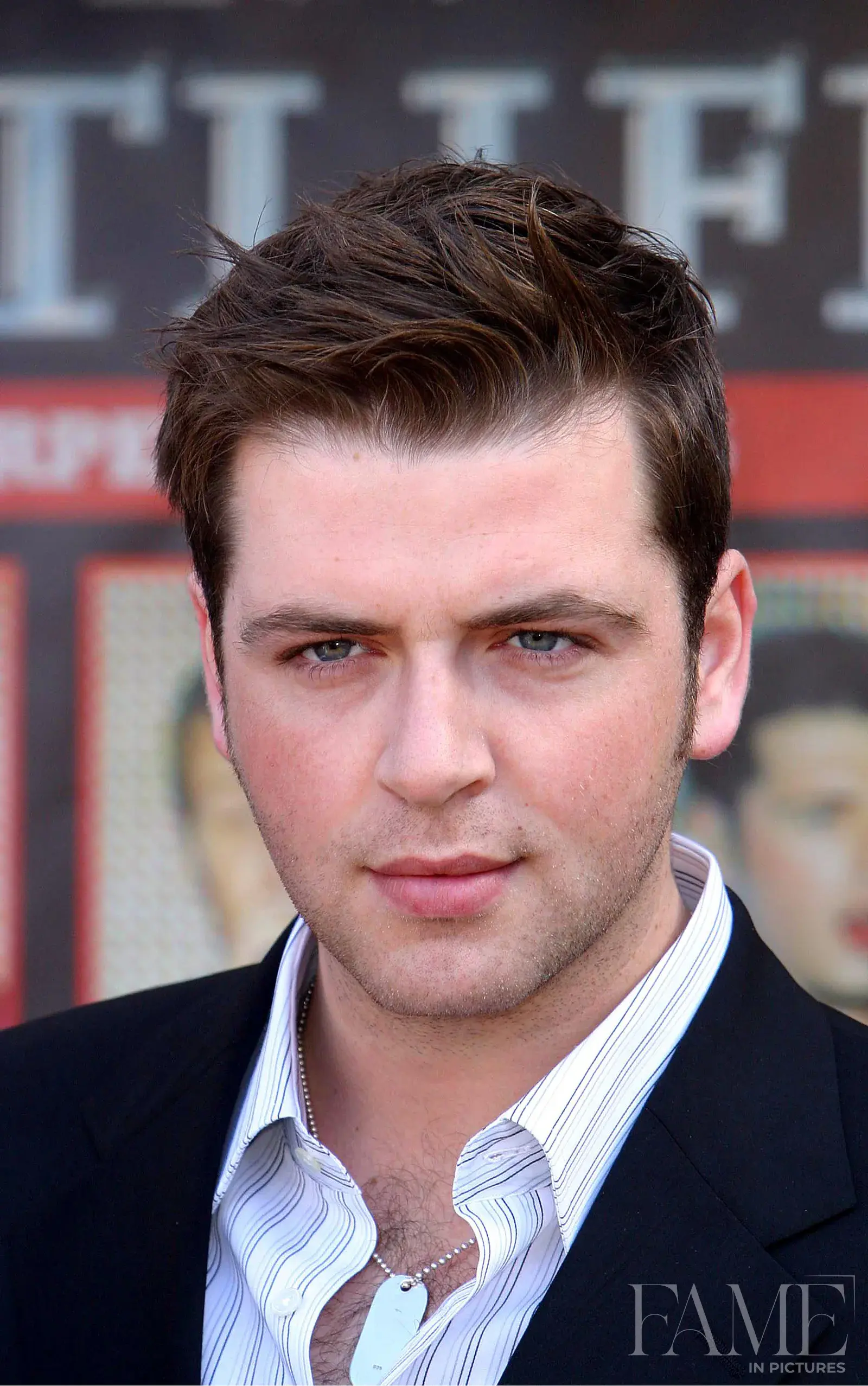 Close-up of Mark from Westlife in a striped shirt and dark jacket at the Wembley tour launch
