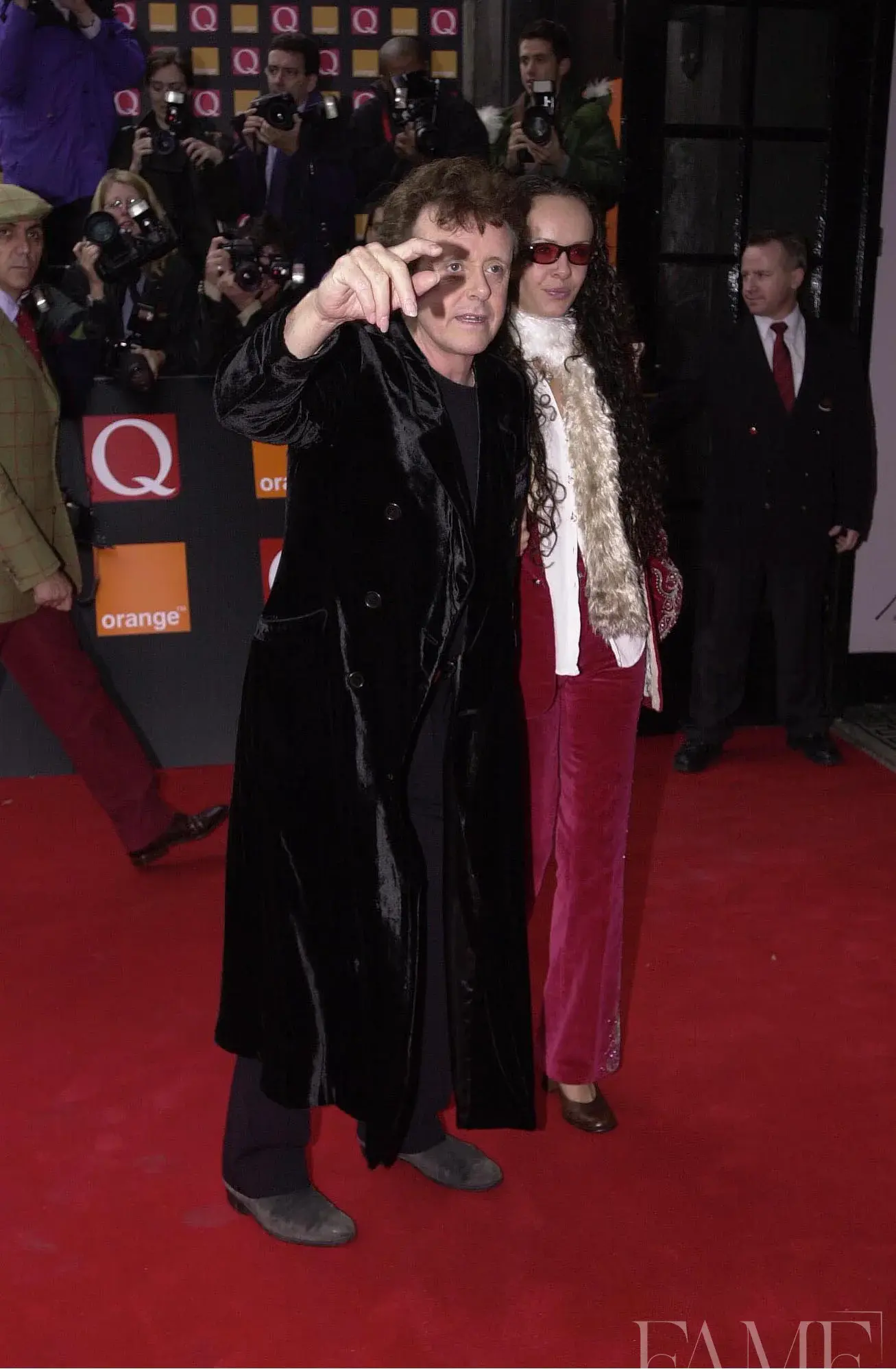 Donovan raising a hand towards the cameras while arriving on the Q Awards red carpet