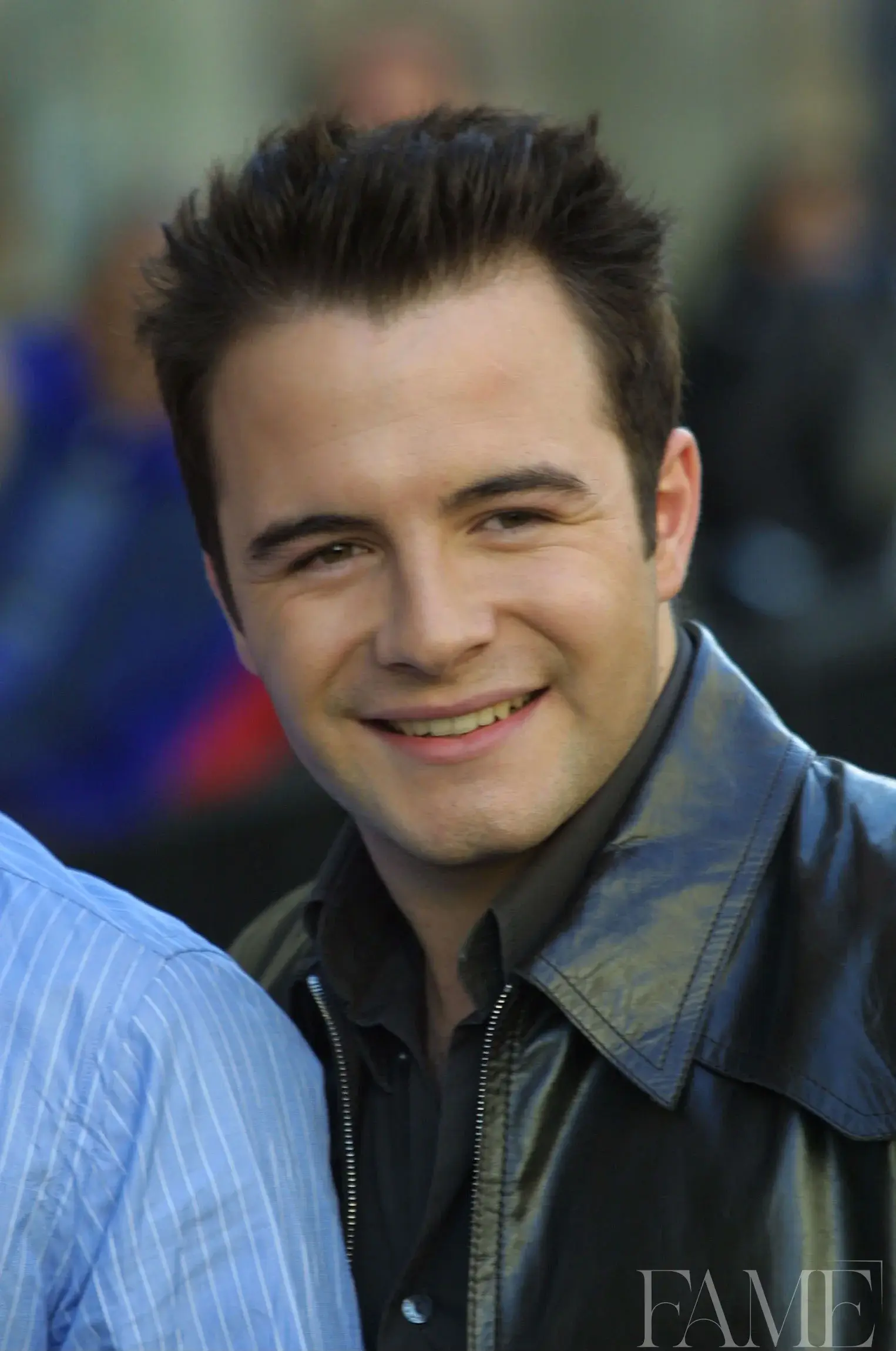 Shane Filan smiling in a dark leather jacket at the Westlife album launch